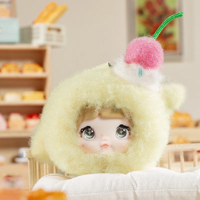 Nommi V9 100% Sweetness Series Blind Box featuring a doll in a fluffy yellow outfit with a cherry embellishment.