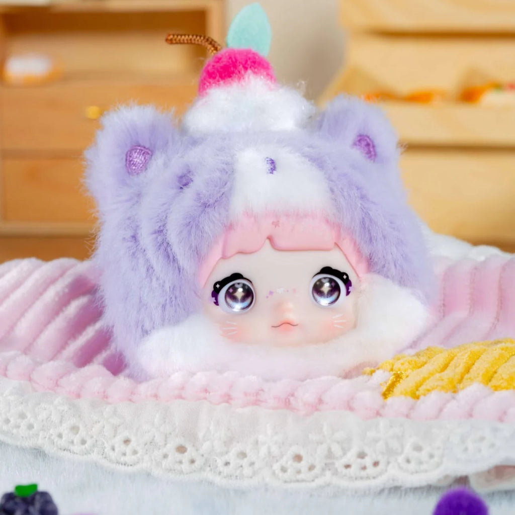 Nommi V9 100% Sweetness Series Blind Box cute doll with fluffy purple hat and pink hair.